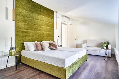 a bedroom with a large bed with a green wall at Sia Mare Residence in Faliraki