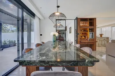 a dining room with a large marble table and chairs at Sia Mare Residence in Faliraki