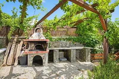 a patio with an outdoor oven in a yard at Holiday home in Kiotari with a terrace or balcony in Kiotari