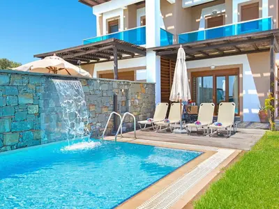 a swimming pool in front of a villa at Holiday home in Kiotari with a terrace or balcony in Kiotari