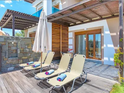 a patio with two chairs and an umbrella at Holiday home in Kiotari with a terrace or balcony in Kiotari