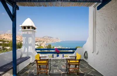 a patio with a table and chairs and a lighthouse at Nefeli house in Archangelos