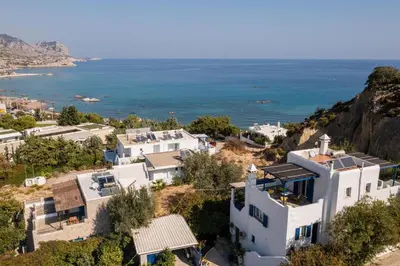 an aerial view of a white house and the ocean at Nefeli house in Archangelos