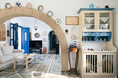 a living room with a white couch and blue cabinets at Nefeli house in Archangelos