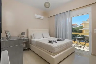 a bedroom with a bed and a view of a balcony at La Maisonette - 4 bedroom villa near the beach in Ialyssos