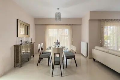 a dining room with a table and chairs and a couch at La Maisonette - 4 bedroom villa near the beach in Ialyssos