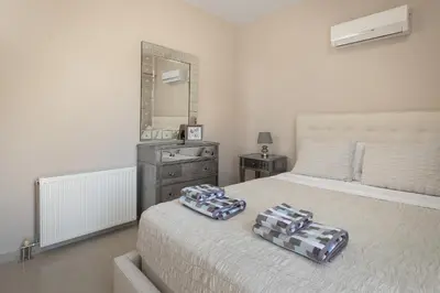 a bedroom with a bed with two pillows on it at La Maisonette - 4 bedroom villa near the beach in Ialyssos
