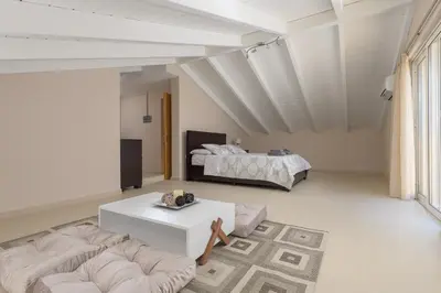 a living room with a couch and a bed at La Maisonette - 4 bedroom villa near the beach in Ialyssos