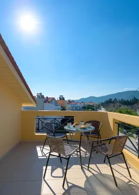 a patio with chairs and a table on a balcony at La Maisonette - 4 bedroom villa near the beach in Ialyssos