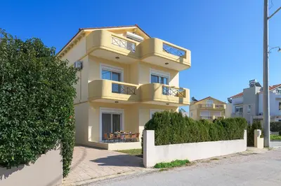 a yellow building with balconies on top of it at La Maisonette - 4 bedroom villa near the beach in Ialyssos