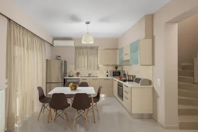 a kitchen with a table and chairs in a kitchen at La Maisonette - 4 bedroom villa near the beach in Ialyssos
