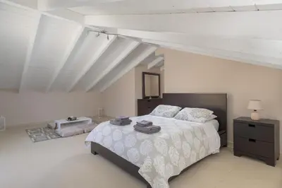a bedroom with a large bed in a white room at La Maisonette - 4 bedroom villa near the beach in Ialyssos