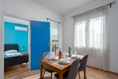 a dining room with a table and chairs and a blue door at Rhodes Central Apartment in Rhodes Town