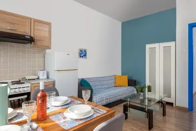 a kitchen and a living room with a table at Rhodes Central Apartment in Rhodes Town