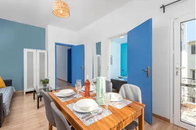 a dining room with blue walls and a table and chairs at Rhodes Central Apartment in Rhodes Town