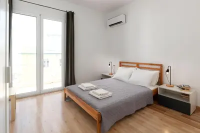 a bedroom with a bed and a large window at Rhodes Central Apartment in Rhodes Town