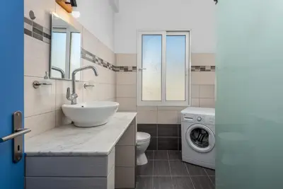 a bathroom with a sink and a washing machine at Rhodes Central Apartment in Rhodes Town