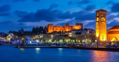 a building with a clock tower next to a body of water at Emerald Dream House#Poiessa, Medieval Town in Rhodes Town