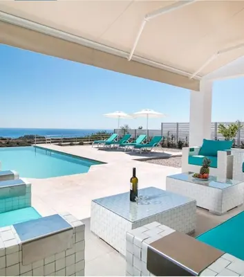an outdoor patio with a view of the pool and the ocean at La Residenzia in Kalithies