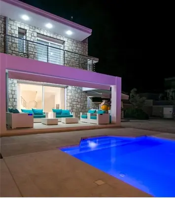 a house with a swimming pool at night at La Residenzia in Kalithies
