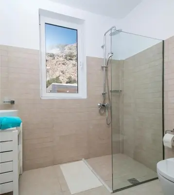 a bathroom with a glass shower with a window at La Residenzia in Kalithies