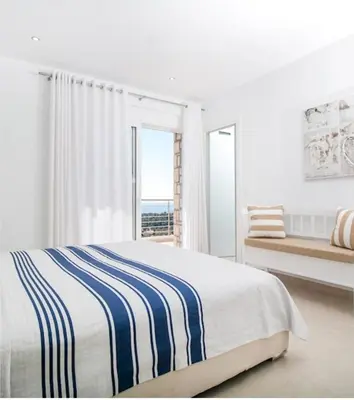a white bedroom with a bed and a window at La Residenzia in Kalithies
