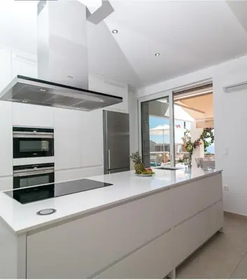 a kitchen with white cabinets and a stove top oven at La Residenzia in Kalithies