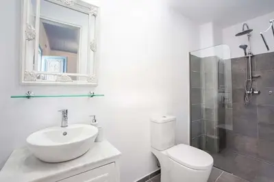 a bathroom with a sink and a toilet and a mirror at Jasmine Suites Poolhouse Rhodos in Koskinou