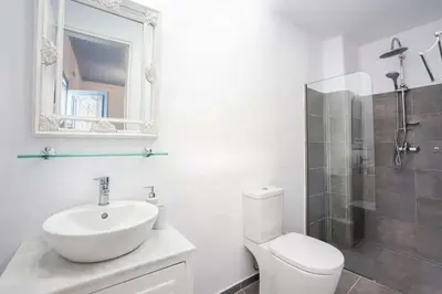 a bathroom with a sink and a toilet and a mirror at Jasmine Suites Poolhouse Rhodos in Koskinou