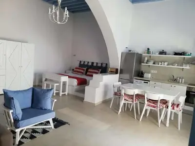 a kitchen and dining room with a table and chairs at Jasmine Suites Poolhouse Rhodos in Koskinou