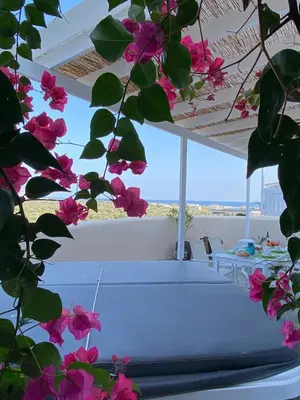 a room with a table and some pink flowers at Afandou Sea View in Afantou