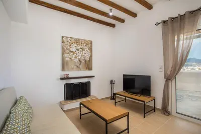 a living room with a tv and a table at Afandou Sea View in Afantou