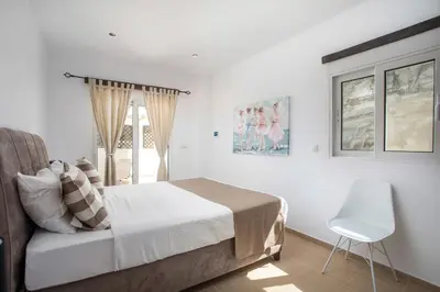 a bedroom with a bed and a chair and a window at Afandou Sea View in Afantou