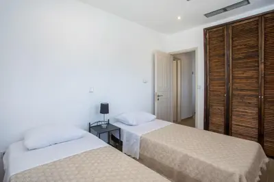 a bedroom with two beds and a table with a lamp at Afandou Sea View in Afantou