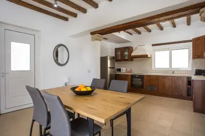 a kitchen and dining room with a wooden table and chairs at Afandou Sea View in Afantou