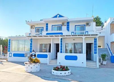 a blue and white house with flowers in front of it at Apollonio Rooms Faliraki Rhodes in Faliraki