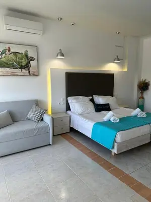 a bedroom with two beds and a couch at Apollonio Rooms Faliraki Rhodes in Faliraki