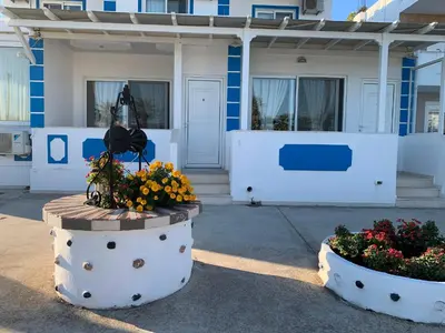 a building with two large pots of flowers in front of it at Apollonio Rooms Faliraki Rhodes in Faliraki