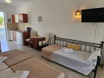a living room with a bed and a kitchen at Apollonio Rooms Faliraki Rhodes in Faliraki