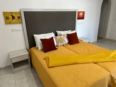 a bedroom with a large bed with yellow sheets and pillows at Apollonio Rooms Faliraki Rhodes in Faliraki