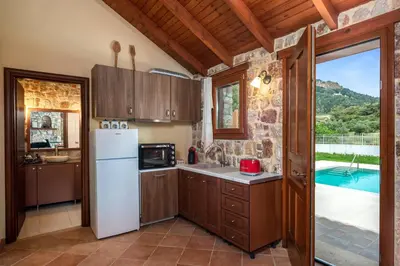 a kitchen with a refrigerator and a pool at Filerolia Stone House in Pastida