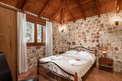a bedroom with a bed in a stone wall at Filerolia Stone House in Pastida