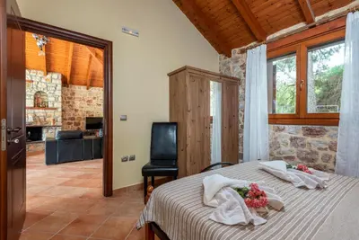 a bedroom with a bed with flowers on it at Filerolia Stone House in Pastida