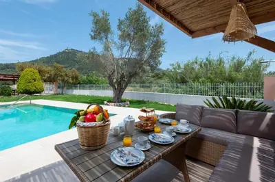 a table with food on it next to a pool at Filerolia Stone House in Pastida