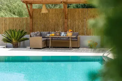 a patio with a table next to a pool at Filerolia Stone House in Pastida