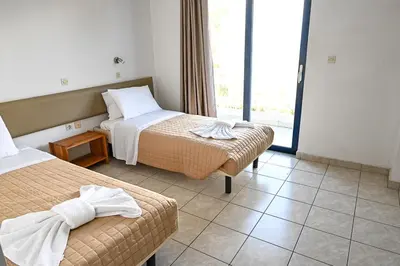 a hotel room with two beds and a window at Amalia Sea Hotel in Rhodes Town