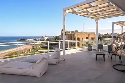 a balcony with couches and a view of the ocean at Amalia Sea Hotel in Rhodes Town