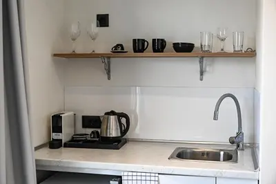 a kitchen with a sink and a counter with glasses at Amalia Sea Hotel in Rhodes Town