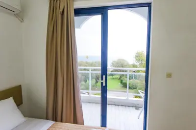 a bedroom with a door open to a balcony at Amalia Sea Hotel in Rhodes Town