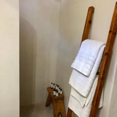 a bathroom with a towel ladder and a table at Constantia in Symi